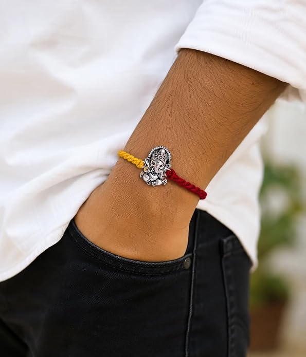 99.5% Pure Silver Lord Ganesha Rakhi with Red and Yellow Sacred Thread wear on hand  Madhaviya Jewels