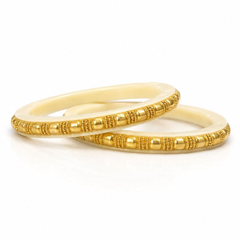 Two gold bangles on a white background